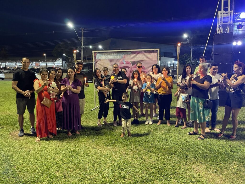 Famílias reunidas com velas acesas em uma edição da Onda de Luz em Londrina.